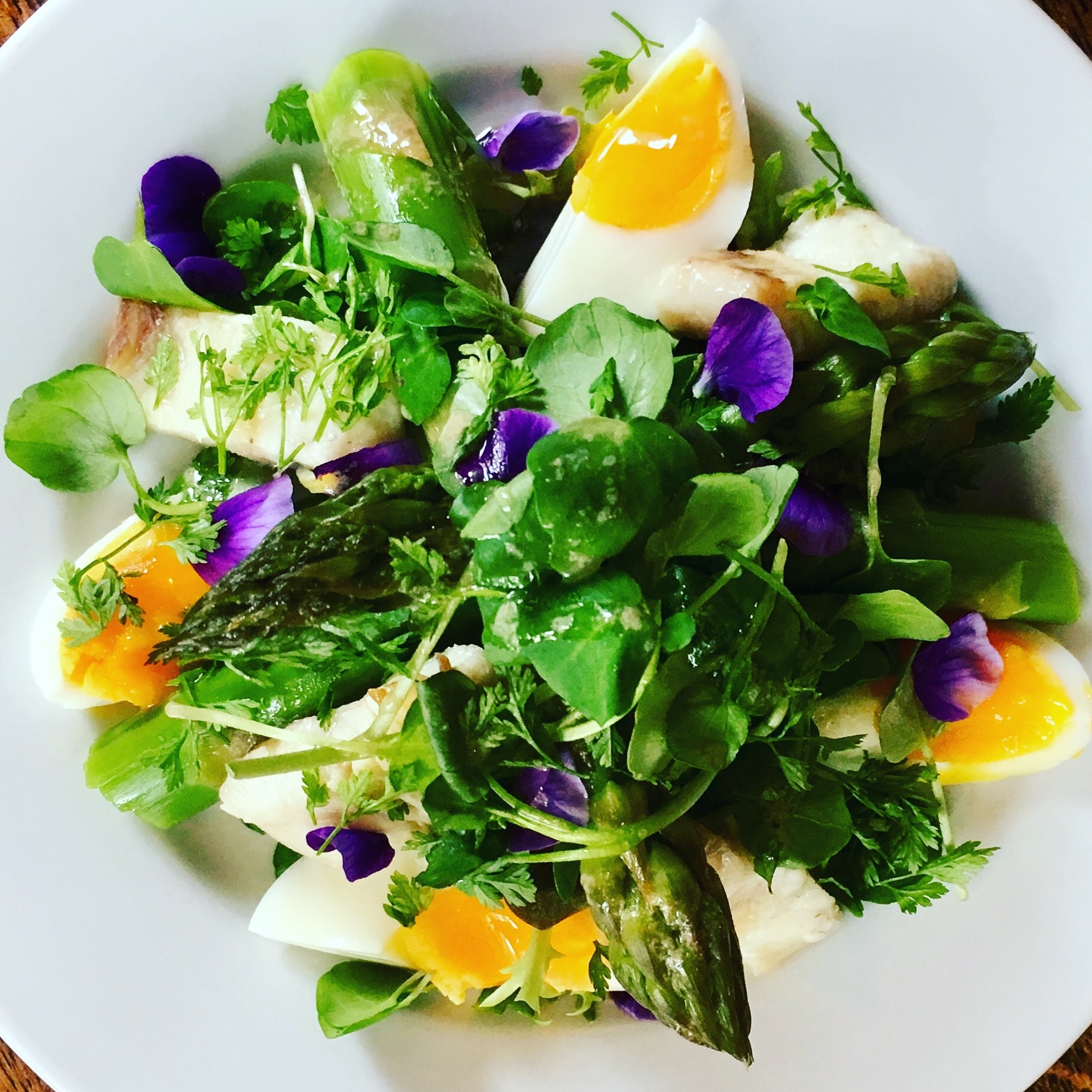 Asparagus with soft egg and edible violet flowers