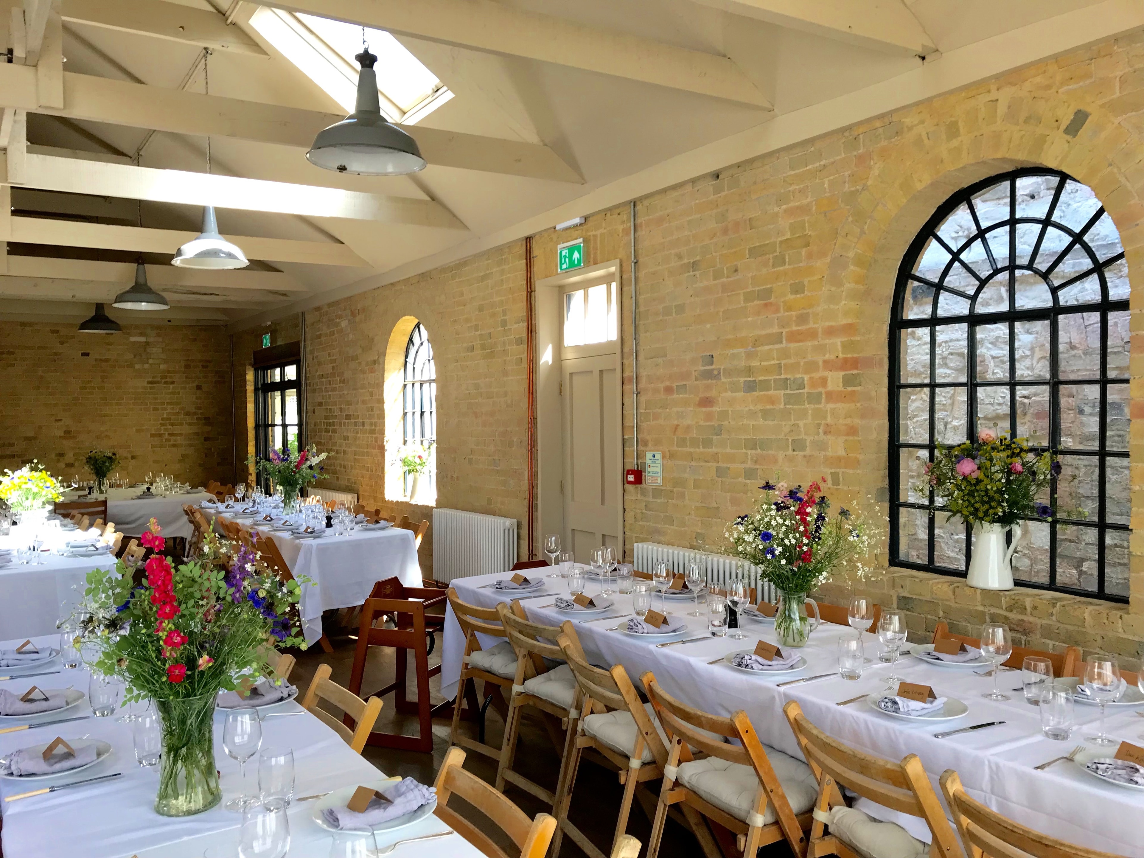 The Coach House set for a daytime wedding reception with wildflower arrangements