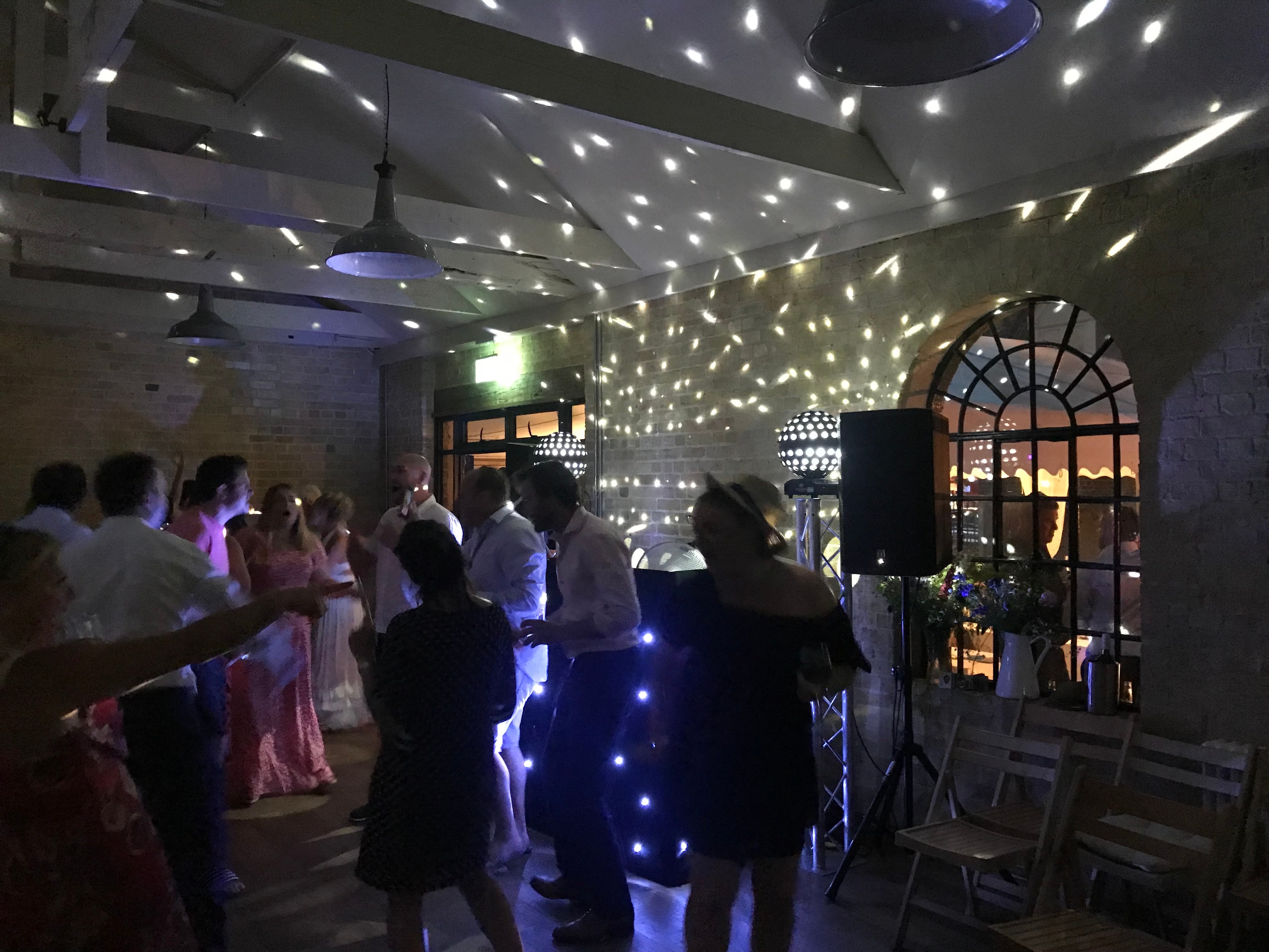 Guests dancing the night away in The Coach House with disco lights